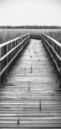 This phone live wallpaper showcases a breathtaking black and white photo of a wooden bridge amidst a scenic landscape