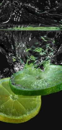 This phone live wallpaper features a captivating digital art rendering of a lime slice falling into a clear water surface