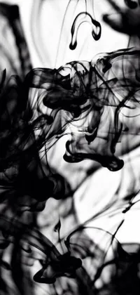 This phone live wallpaper features a dynamic black and white photo of ink swirling in water