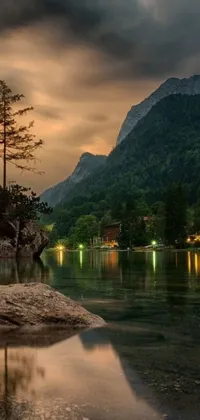This phone live wallpaper showcases a beautiful scene with a serene body of water and majestic mountains in the background