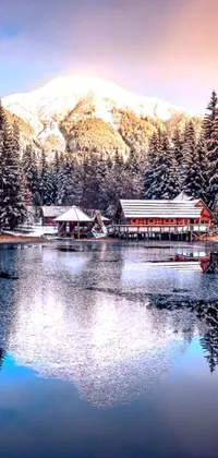 Experience nature's breathtaking beauty on your phone with this live wallpaper featuring a serene lake, snow-capped mountain, and a cozy house in the forest