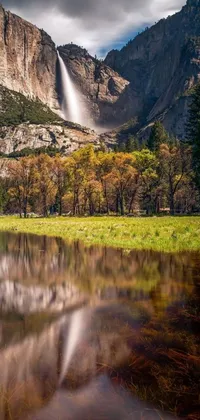 This beautiful live wallpaper features a serene body of water with a stunning cascade in the background, set against a backdrop of breathtaking cliffs, a lush meadow, and majestic mountain peaks