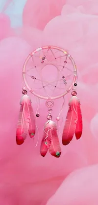 This phone live wallpaper features a close-up of a pink dream catcher embedded with gemstones in a brightly lit room