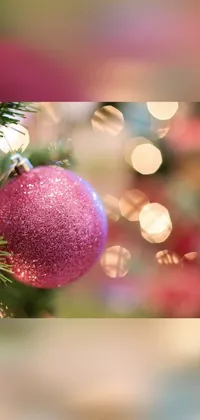 This phone live wallpaper showcases a charming pink ornament hanging from a Christmas tree, making it perfect for adding a touch of festive magic to your phone