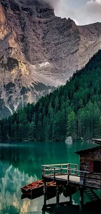 Transform your phone's home screen with the breathtaking live wallpaper featuring a peaceful lake, towering mountains, lush forests, and a lovely wooden house