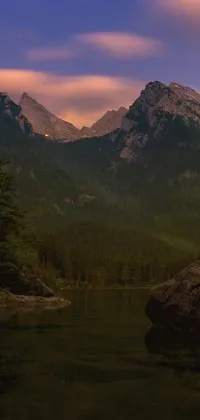 This live wallpaper for phones depicts a breathtaking natural landscape with a captivating rugged mountain range in mellow dusk lighting