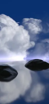This phone live wallpaper depicts realistic rocks atop water, with heavenly clouds in the background
