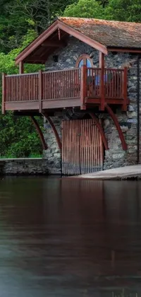 This phone live wallpaper features a serene wooden cabin with a charming balcony overlooking a placid waterway bridged by a small bridge