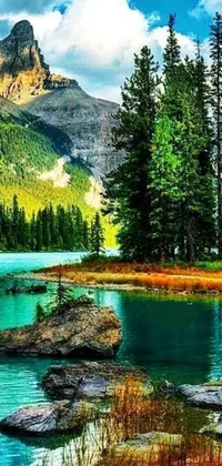 This phone live wallpaper showcases a picturesque natural scene – a clear body of water enclosed by tall, lush trees and grand mountain ranges in the distance