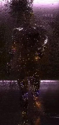 This phone live wallpaper features a visually stunning scene of a hologram standing in the rain while wearing ferrofluid armor
