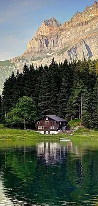 This mobile live wallpaper depicts a mesmerizing house amidst a serene lake with a commanding background of Swiss Alps Mountains