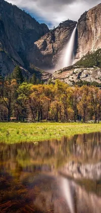 Experience the tranquil beauty of nature with this stunning live wallpaper featuring a serene body of water, a cascading waterfall, and a picturesque mountain with a lush meadow in the background