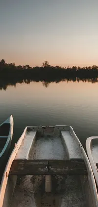 This mobile live wallpaper showcases a serene evening atmosphere with two boats resting on still waters