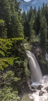 Experience the beauty of nature with this amazing live wallpaper! The wallpaper features a stunning waterfall flowing through a lush green forest, set against the breathtaking backdrop of the Dolomites