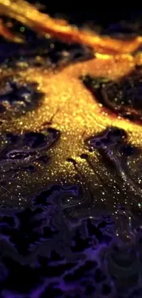 This phone live wallpaper offers a stunning close-up view of water droplets on a surface in shades of gold and purple