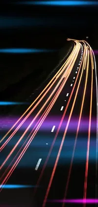 This phone wallpaper showcases a breathtaking scene of a highway at night taken with long exposure photography