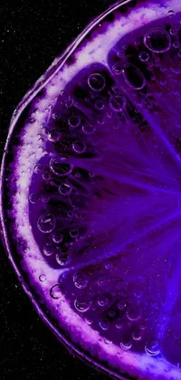 This phone live wallpaper features a close-up of a lemon slice with a purple bioluminescence that creates a stunning and captivating effect