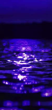 This live wallpaper for your phone features a vibrant purple light reflecting on a picturesque body of water, inspired by abstract art and holography