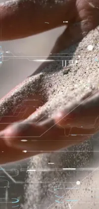 This stunning live wallpaper features a close-up view of hands holding sand, with realistic and fluid powder-like particles falling and moving around the phone screen
