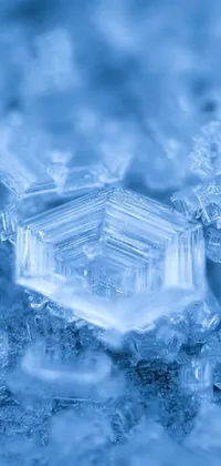 This phone live wallpaper features a stunning snowflake sitting atop an icy pile