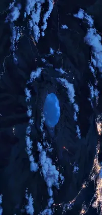 This mesmerizing live wallpaper takes you on a journey into a volcanic landscape at night, captured at an aerial view from a satellite