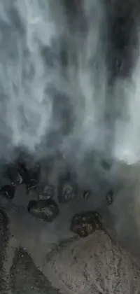 This live phone wallpaper showcases a captivating image of a fire hydrant standing tall next to a magnificent waterfall, surrounded by breathtaking drone point of view video art
