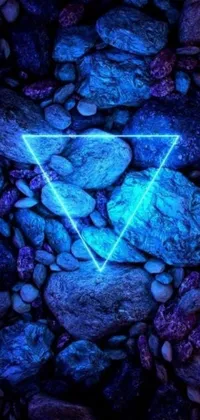 This phone live wallpaper features a stunning blue triangle on top of a rock pile with a neon atmosphere