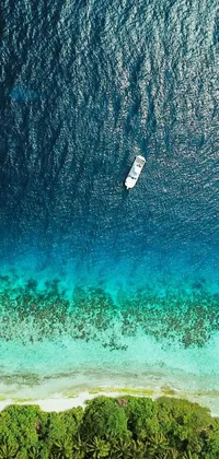 This phone live wallpaper showcases a calming water scene with a boat and beautiful reefs