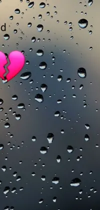 This android live wallpaper showcases a pink heart atop a rain-covered window