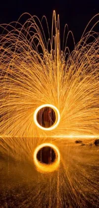 This phone live wallpaper features a captivating image of spinning steel wool in the dark, sourced from Pexels