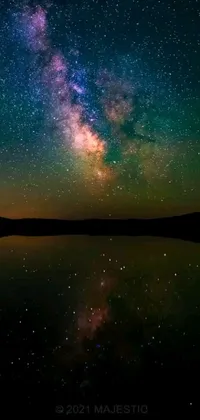 Get lost in a marvelous celestial display with this live phone wallpaper featuring stars in the night sky and a tranquil lake bordered by majestic mountains