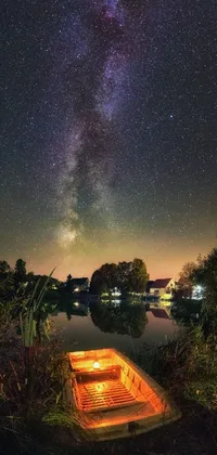 Discover a calming phone live wallpaper featuring a small boat on lush green fields with a breathtaking view of the milky way galaxy