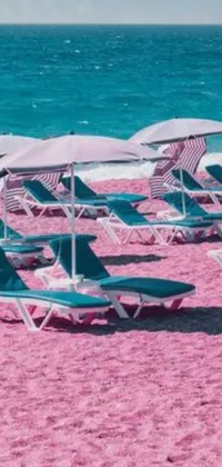 This phone live wallpaper displays a serene beach scene with vibrant lawn chairs and colorful umbrellas against the ocean