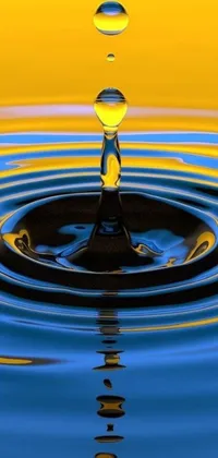 This phone live wallpaper depicts a clear water droplet positioned in the midst of a yellow and blue background