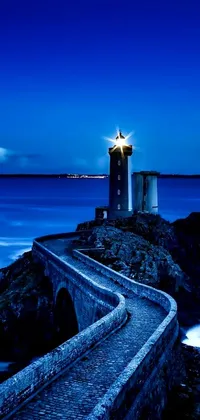 This live wallpaper depicts a scenic lighthouse by the ocean at night