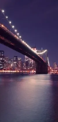 Decorate your phone screen with this delightful live wallpaper featuring a picturesque bridge and sparkling waters, set against the enchanting backdrop of nighttime in New York