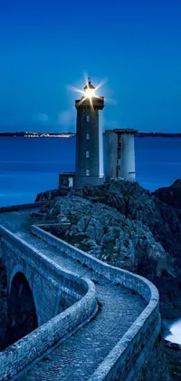 Experience the beauty of the Lighthouse at Night Live Wallpaper! This stunning live wallpaper depicts a lighthouse on top of a cliff, overlooking the vast ocean