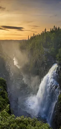 Looking for a serene live wallpaper to liven up your phone screen? Look no further than this high-quality wallpaper featuring a breathtaking waterfall set in lush greenery and surrounded by mountainous terrain in Alaska