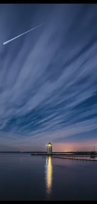 This stunning phone live wallpaper features a lighthouse perched atop a serene body of water