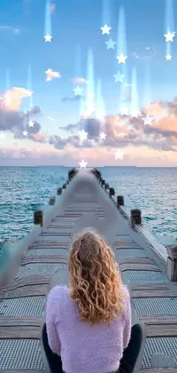 This ocean-themed phone live wallpaper depicts a woman sitting on a dock, looking out at the panoramic view of the sea in Australia