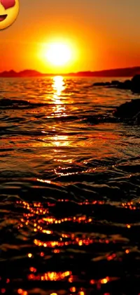 This stunning live wallpaper features a sunset over a sparkling body of water with brilliant, golden hues reflecting on the surface