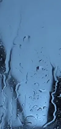 This live wallpaper for your mobile phone features a video art still, showcasing a window covered in raindrops