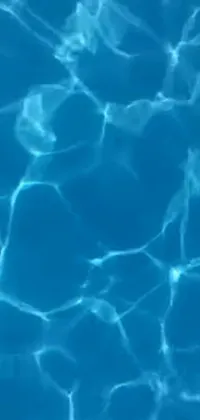 This phone live wallpaper captures a stunning close-up shot of glistening water in a swimming pool
