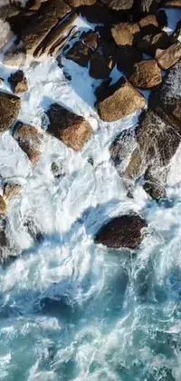 Immerse yourself in the beauty and power of nature with this stunning phone live wallpaper featuring a man standing on a rock next to the ocean