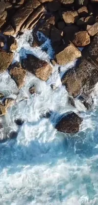 This phone live wallpaper showcases a surfer riding the waves, surrounded by streams and rocks
