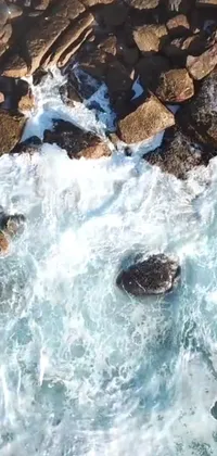 This phone live wallpaper features a stunning bird's eye view of serene waters and rocky terrain