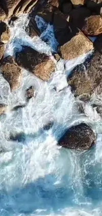 This live wallpaper offers a stunning bird's eye view of a rugged rocky coastline