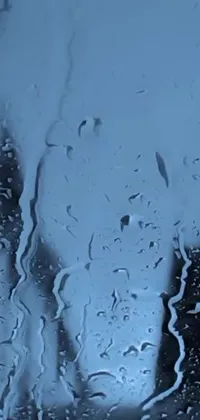 Looking for a captivating live wallpaper for your iPhone? This video art showcases a rain-covered window with a desaturated blue filter to create a dramatic effect