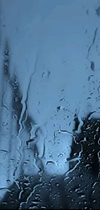 This phone live wallpaper depicts a rain-covered window in mesmerizing blue hues