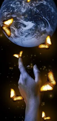 This phone live wallpaper showcases an astounding digital art piece that portrays a hand stretching towards the sky as vibrant yellow butterflies flutter through the atmosphere around a sphere representing earth